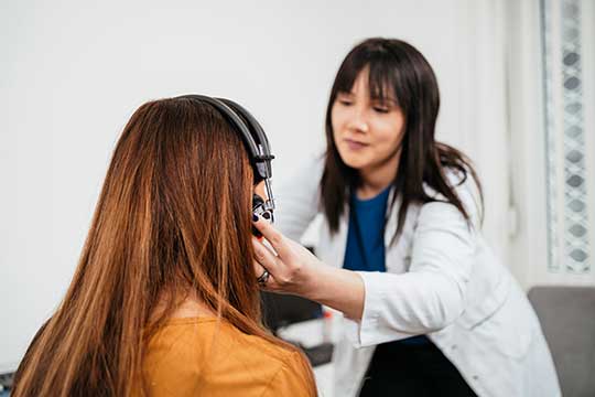 A woman having her hearing tested to see if she would benefit from hearing aids.